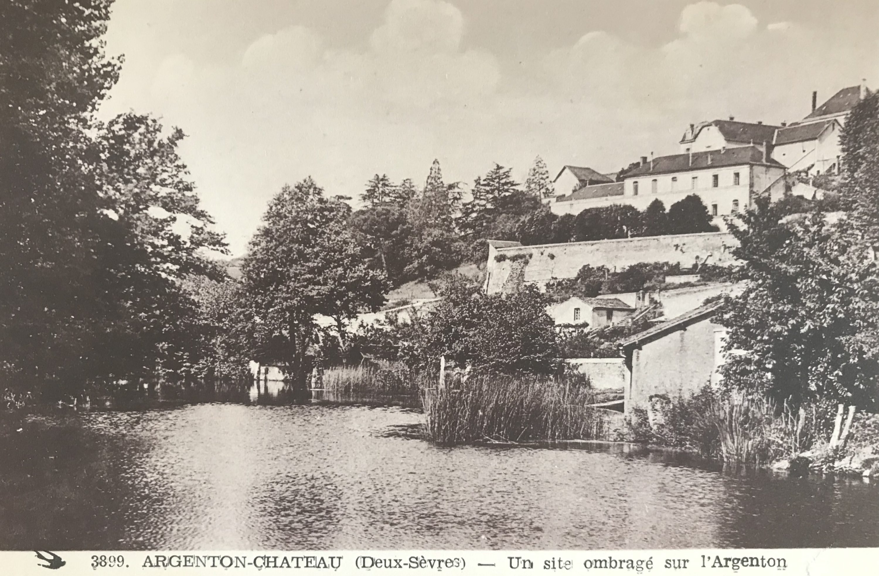 An ancient postcard showing l’Ancienne Ecole from the river below